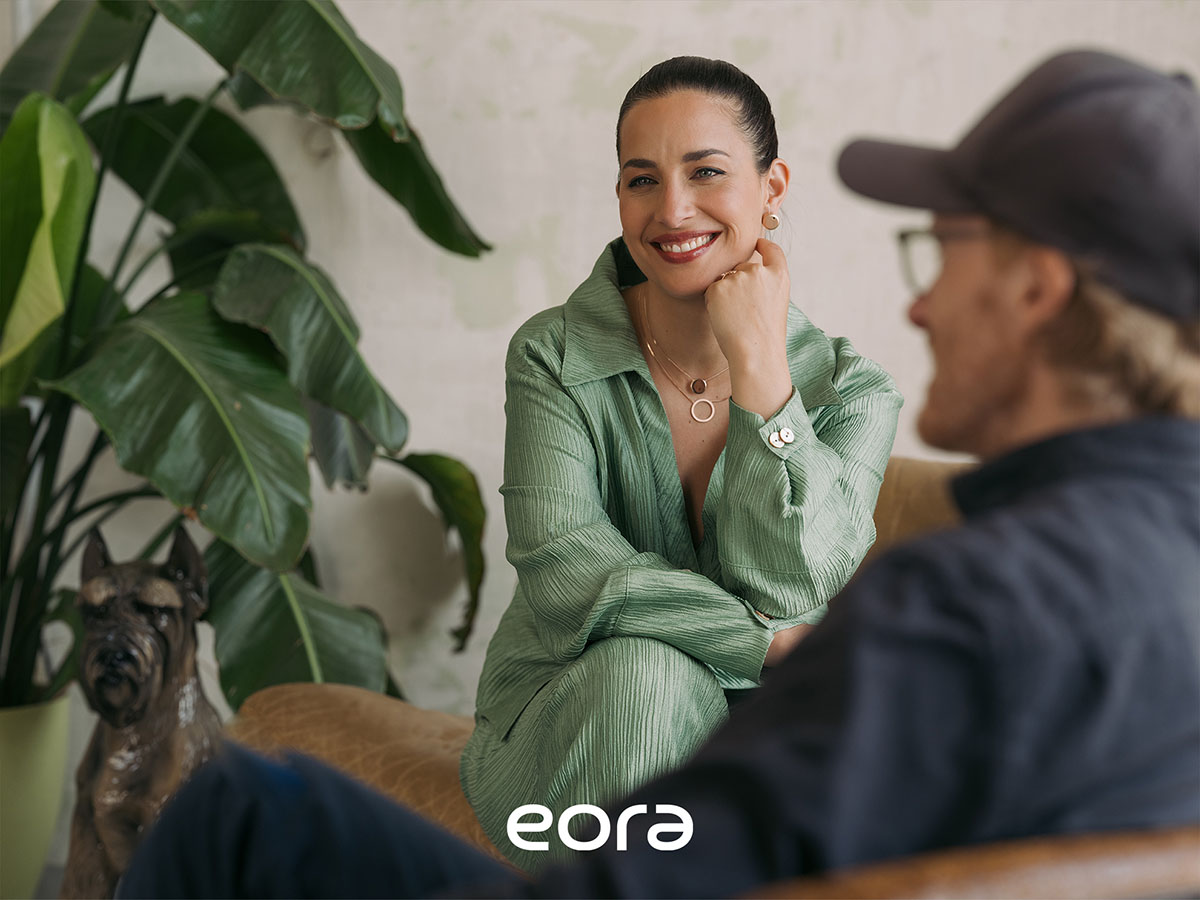 Frau trägt Eora Hörschmuck im Beratungsgespräch – moderne Hörlösung, die Design und Funktion verbindet
